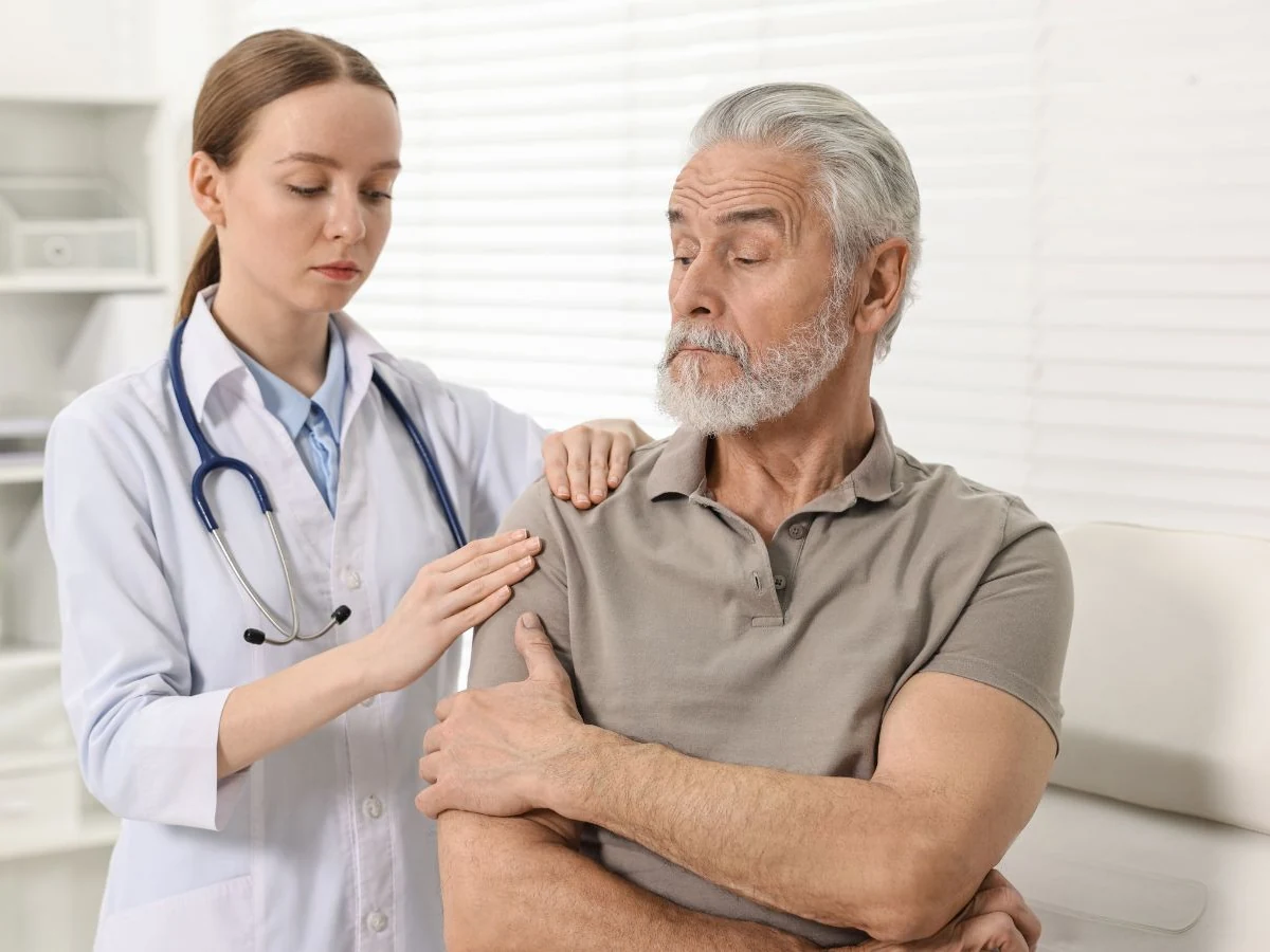 Medico ortopedico che visita la spalla di un paziente