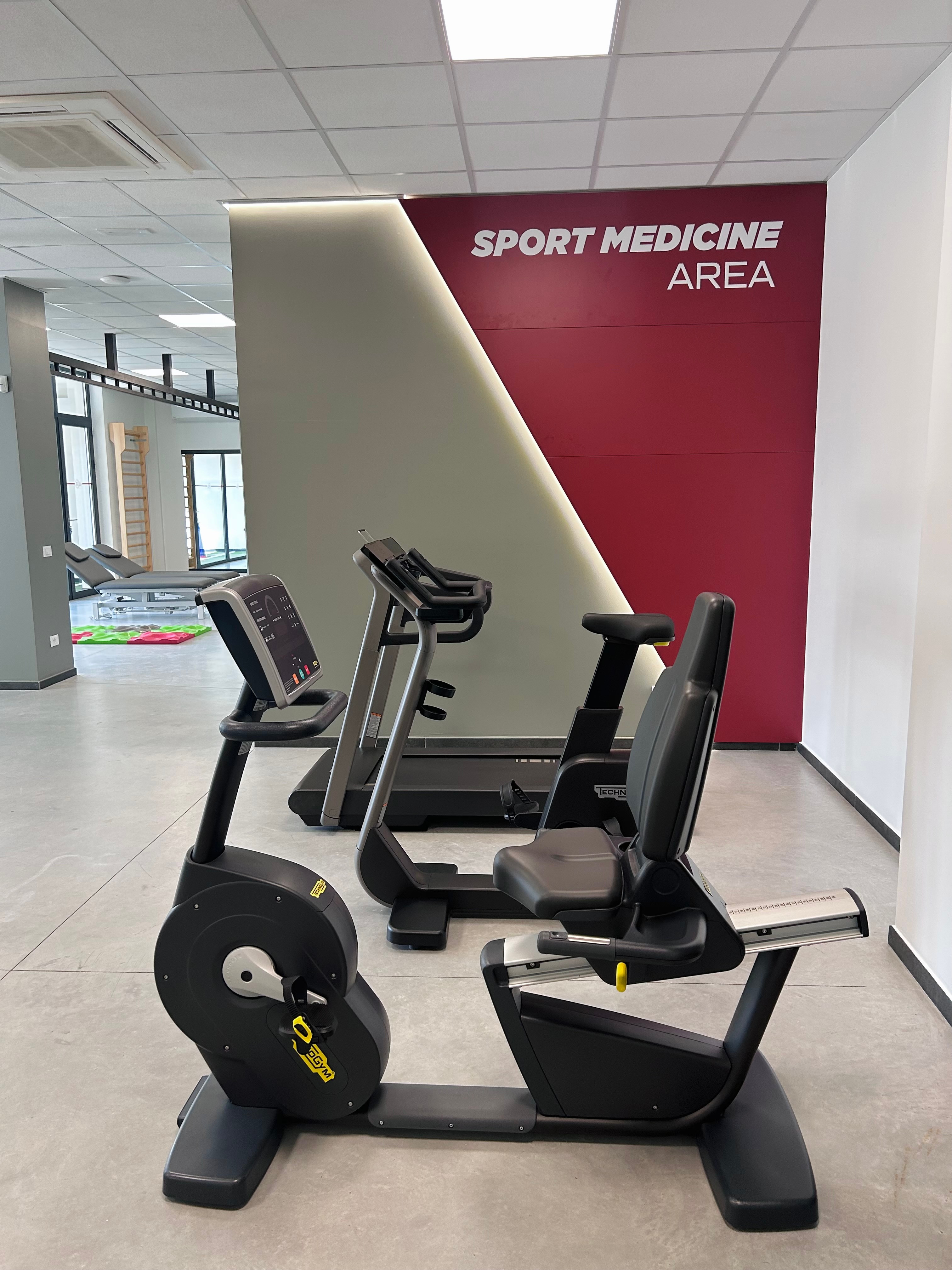 palestra con scritta Sport Medicine Area sulla parete. Tapis roulant e cyclette