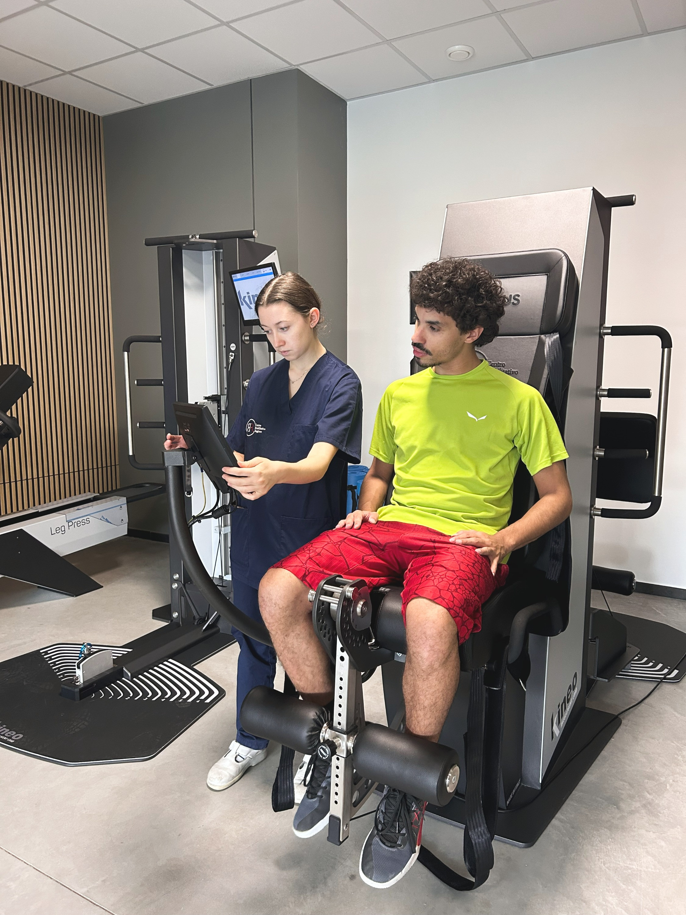 Un nostro macchinario Kineo per le gambe all'interno della Sport Medicine Area CRR FisioFit del Centro Medico Reggiano con la nostra fisioterapista ed un cliente